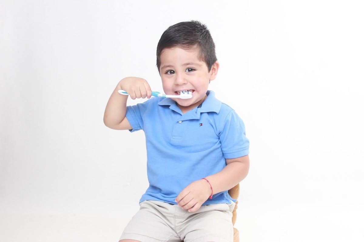Niño sonriendo mientras se cepilla los dientes